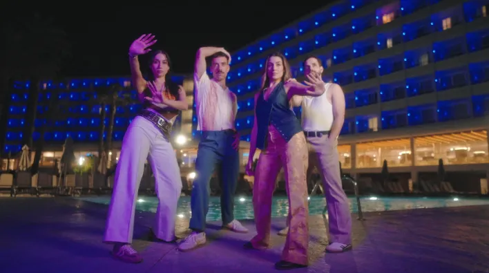Creative team posing on a rooftop during a brand shoot at sunset.